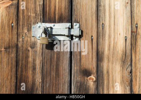 alte Holztür mit Vorhängeschloss, Metall-Riegel Stockfoto