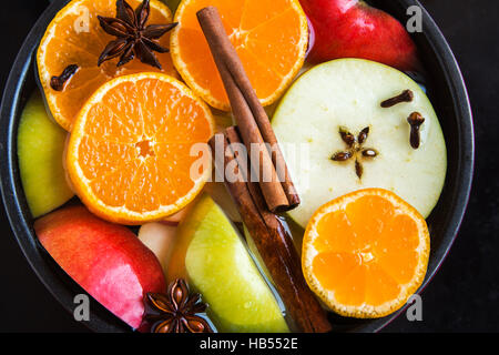 Glühwein orange Apfelwein (Punch) in Pfanne auf schwarzem Hintergrund, Ansicht von oben - langsam kochen würzige hausgemachte festliche trinken Stockfoto