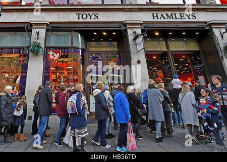 Shopper-Warteschlange Hamleys Spielwarenladen am Regents Street in London am ersten Sonntag im Dezember treten. Stockfoto