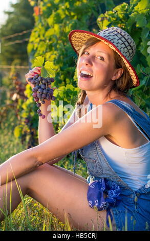 Glückliche Frau genießen frische Trauben im Weinberg Stockfoto