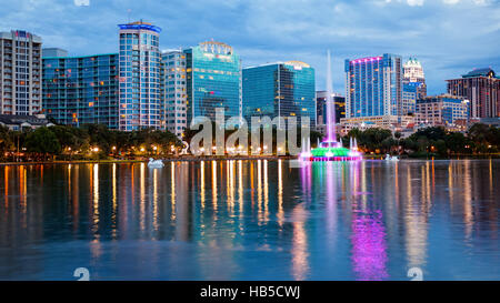 Orlando, Florida Stadt Skyline und Wasser-Brunnen in der Nacht in Lake Eola Park, Gebäude Logos verschwommen für den gewerblichen Einsatz Stockfoto