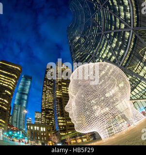 Eine Nacht, fisheye Ansicht der Skulptur Wonderland von Jaume Plensa vor The Bow Wolkenkratzer in Calgary, Alberta, Kanada. Stockfoto