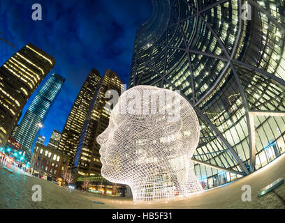 Eine Nacht, fisheye Ansicht der Skulptur Wonderland von Jaume Plensa vor The Bow Wolkenkratzer in Calgary, Alberta, Kanada. Stockfoto