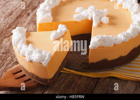 Ein leckeres Stück Kürbis-Käsekuchen mit gepeitschter Creme close-up auf dem Tisch. horizontale Stockfoto