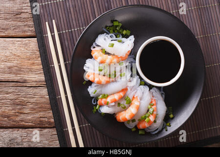 Japanisches Essen: Shirataki mit Garnelen, Frühlingszwiebeln und Sojasauce auf eine Platte Nahaufnahme. Horizontale Ansicht von oben Stockfoto