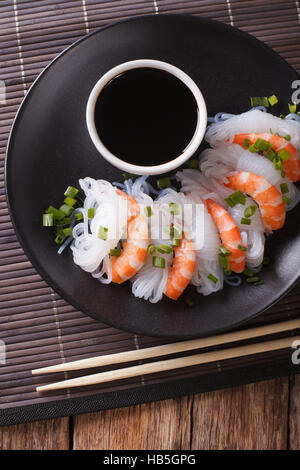 Japanisches Essen: Shirataki mit Garnelen, Frühlingszwiebeln und Sojasauce auf eine Platte Nahaufnahme. vertikale Ansicht von oben Stockfoto