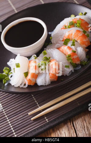 Shirataki mit Garnelen, Schnittlauch und Soja-Sauce auf einer Platte Nahaufnahme. vertikale Stockfoto