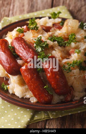 Niederländische winter Mahlzeit: Stamppot von Kartoffeln, Kohl und Karotten, mit Wurst Nahaufnahme auf einer Platte. vertikale Stockfoto