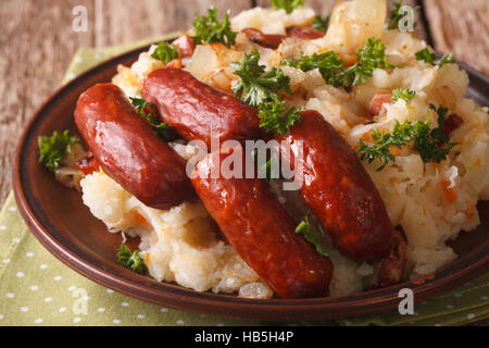 Niederländische Küche: Stamppot aus Kartoffeln, Sauerkraut und Karotten, mit Wurst Nahaufnahme auf dem Tisch. horizontale Stockfoto