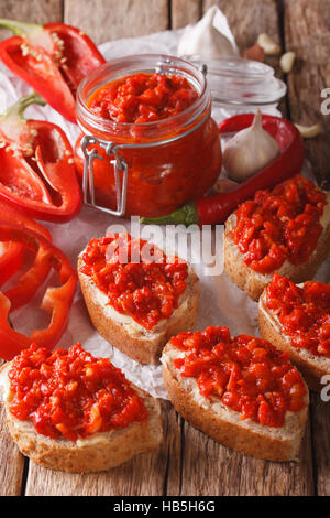 Relish (Ajvar) der geröstete rote Paprika auf Toast Scheiben close-up auf dem Tisch. Vertikal Stockfoto