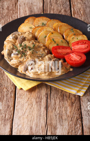 Diana-Steak mit Pilzsauce und Bratkartoffeln Nahaufnahme auf einem Teller auf den Tisch. vertikale Stockfoto