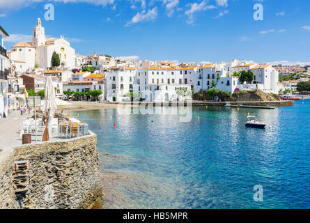 Weiß getünchten Dorf Cadaqués gekrönt von der Kirche Santa Maria mit Blick auf Boote in den blauen Wassern der Bucht von Cadaqués, Spanien Stockfoto