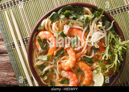 Malaysische Laksa Suppe mit Garnelen hautnah in einer Schüssel auf dem Tisch. horizontale Ansicht von oben Stockfoto