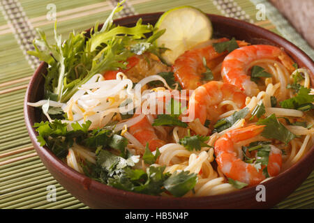 Malaysische Laksa Suppe mit Garnelen hautnah in einer Schüssel auf dem Tisch. horizontale Stockfoto