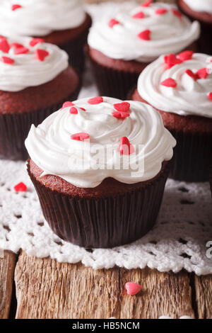 Red Velvet Cupcakes dekoriert mit Herzen Nahaufnahme auf dem Tisch. vertikale Stockfoto