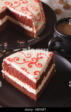 leckeres Stück rotem Samt Kuchen auf eine Platte Nahaufnahme auf dem Tisch. vertikale Stockfoto