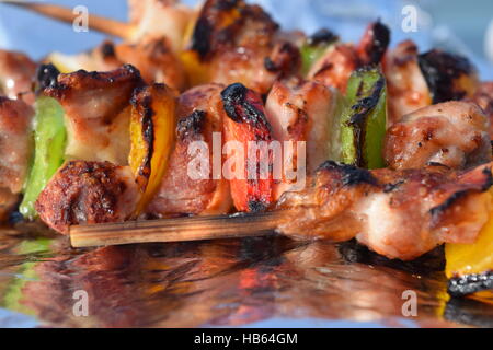 Knusprige Hähnchen-Spieße auf Alufolie mit unscharfen Hintergrund Stockfoto