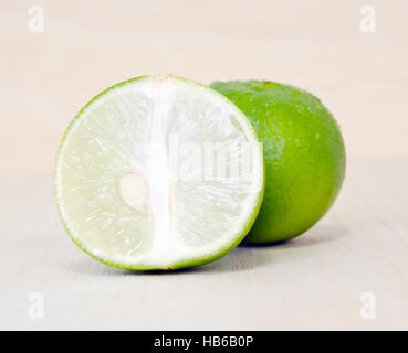 Zitrone Obst (andere Namen sind auf Französisch, Zitrusfrüchte, Lindgrün, Key Lime, persische Limette, Kaffernlimette, Wüste Kalk Kalk) mit einem halben Querschnitt und p Stockfoto