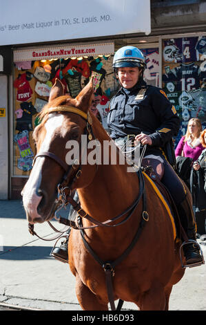 Polizei, ehrliches Porträt, weibliche New Yorker Polizistin auf Pferderücken beobachtet Touristen am Times Square, Manhattan Stockfoto