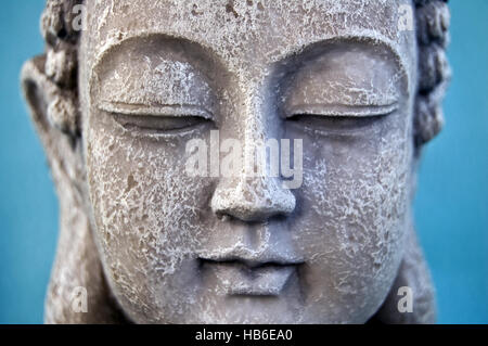 Buddha Gesicht auf blauem Hintergrund. Hautnah. Stockfoto