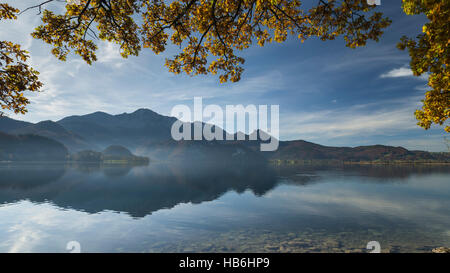 Bäume mit bunten Herbst Blätter über den See Kochelsee reflektieren das Panorama der Mount Herzogstand in den Bayerischen Alpen, Bayern, Deutschland Stockfoto