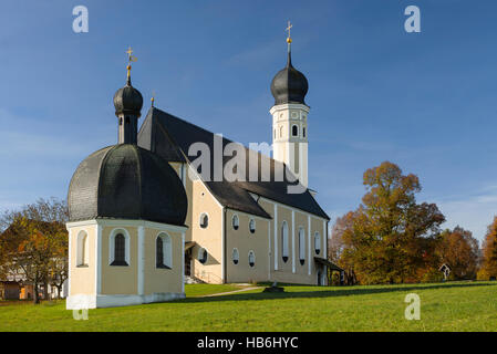 Bunte Fassade, Kirchtürme und Dach der barocken Wallfahrtskirche Wilparting und Kapelle gegen den blauen Himmel in der Morgen Sonne, Bayern, Deutschland Stockfoto