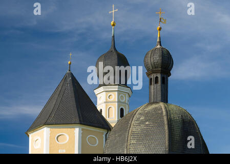 Bunte Fassade, Kirchtürme und Dach der barocken Wallfahrtskirche Wilparting und Kapelle gegen den blauen Himmel in der Morgen Sonne, Bayern, Deutschland Stockfoto