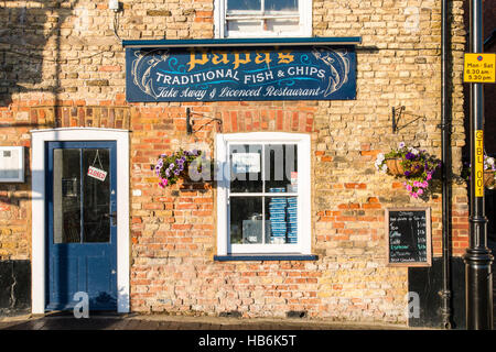 England, Sandwich. Papas traditionellen Fisch- und Chip Shop, Restaurant. Ziegelgebäude, sonnendurchfluteten, Eingang und Schild über der Tür. "Geschlossen"-Schild hängt. Stockfoto