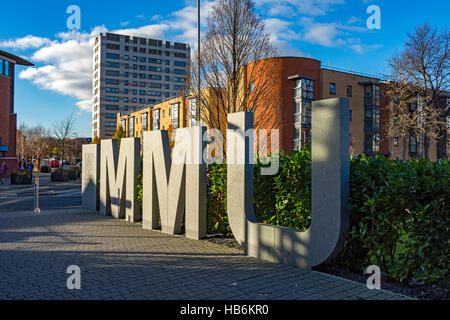 Großer Stein oder Beton MMU-Zeichen für Manchester Metropolitan University, auf einem Steg off Grenze Lane, Manchester, UK Stockfoto