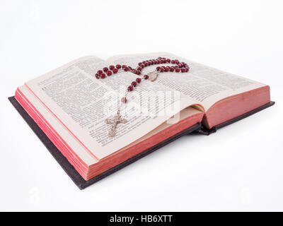 Rosenkranz über eine alte Bibel in Portugiesisch schneiden Sie geschrieben oder auf weißem Hintergrund Stockfoto