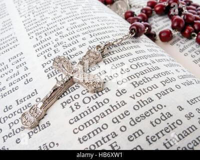 Rosenkranz über eine alte Bibel in Portugiesisch geschrieben. Nahaufnahme Detail. Stockfoto