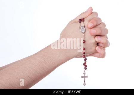 Weibliche Hände geschlossen im Gebet Holding einen Rosenkranz auf weißem Hintergrund Stockfoto