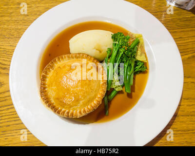 Leckeres Essen Steak und Ale Pie mit Kartoffelpüree zarte Stängel Brokkoli und Soße Stockfoto