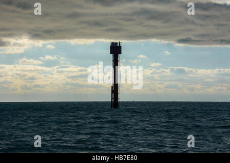 Mittleren Kanal marker Post scheint zu sein, die den starken November Himmel voller Wolken über dem tiefblauen Meer Stockfoto