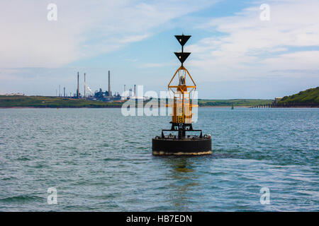 South Hook Süden kardinal Marker mit pembrokeshire Raffinerie- und Winkel Rettungsboot Station im Hintergrund Stockfoto