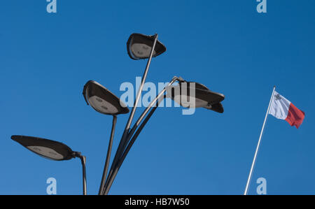 Array von vier Straßenlaternen und die Nationalflagge von Malta in minimaler und interessanter Zusammensetzung Stockfoto