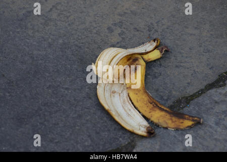 Weggeworfene Bananenhaut, die auf öffentlichen Pfaden liegt und die Gefahr des Abrutschens und Herunterfallens birgt Stockfoto