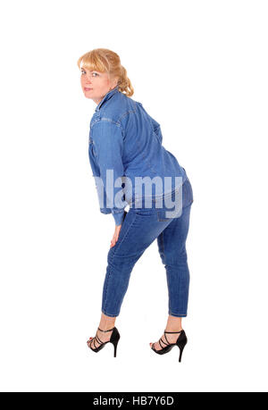 Eine hübsche Frau in Jeans Hose und Jacke im Profil stehen, Blick über ihre Schulter, für weißen Hintergrund isoliert. Stockfoto