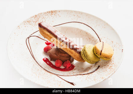 Eclair mit Makronen, Schokoladeneis und Himbeersauce Stockfoto