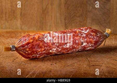 Italienische Salami auf Holzbrett, auf hölzernen Hintergrund Stockfoto