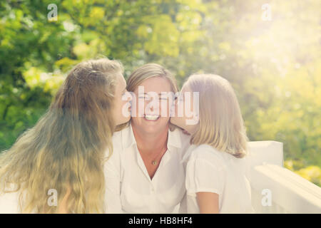 Mutter empfangen Küsse von ihren Töchtern Stockfoto