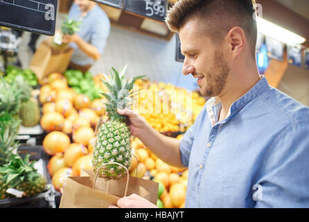 Junger Mann, frisches und gesundes Obst kaufen Stockfoto