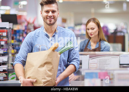 Der junge Mann beendet seinen Einkauf Stockfoto