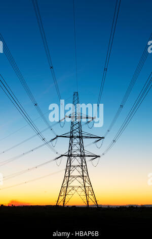 Die Silhouette des elektrischen Pylons vor dem Morgenhimmel. Cotswolds, England Stockfoto