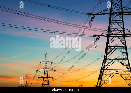 Elektrische Pylonen Silhouette vor dem Morgenhimmel. Cotswolds, England Stockfoto