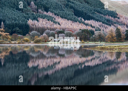 St Marys Loch im Winter mit Haus und Baum Reflexionen. Perth und Kinross, Schottland. Stockfoto
