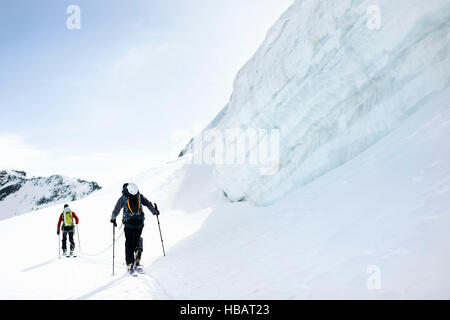 Rückansicht der Bergsteiger Skitouren auf schneebedeckte Berge, Saas Fee, Schweiz Stockfoto
