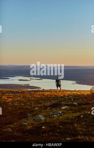 Menschen, die Ruhe nach dem Ausführen auf Klippe bei Sonnenuntergang, Keimiotunturi, Lappland, Finnland Stockfoto