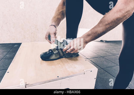 Zugeschnittenen Schuss des Mannes Befestigung Trainer in cross-training Fitness-Studio Stockfoto