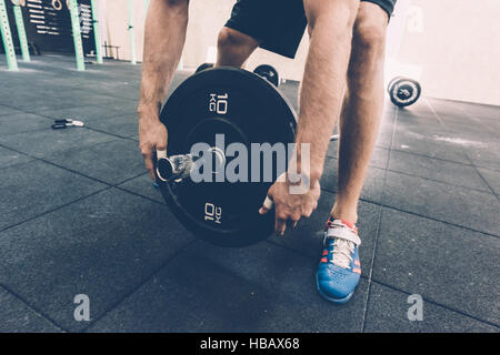 Zugeschnittenen Schuss des Mannes Vorbereitung Langhantel in cross-training Fitness-Studio Stockfoto